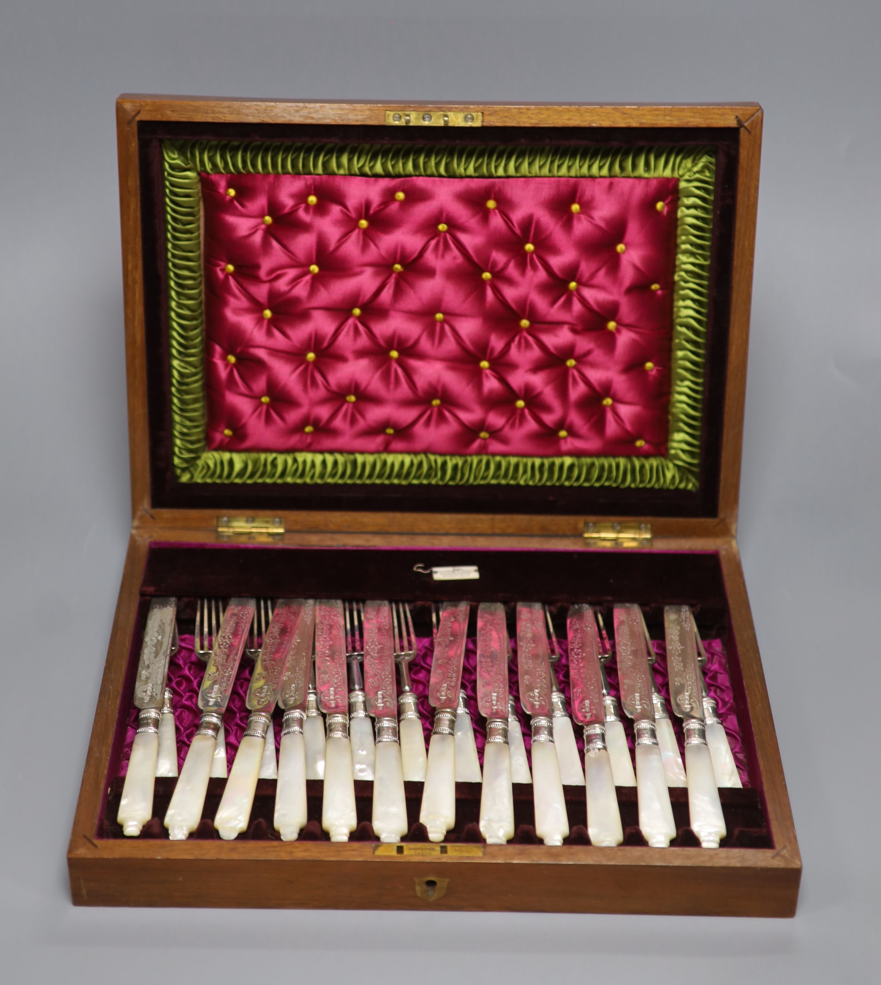 A cased set of twelve pairs of mother of pearl handled silver dessert eaters, Walker & Hall, Sheffield, 1897/1904